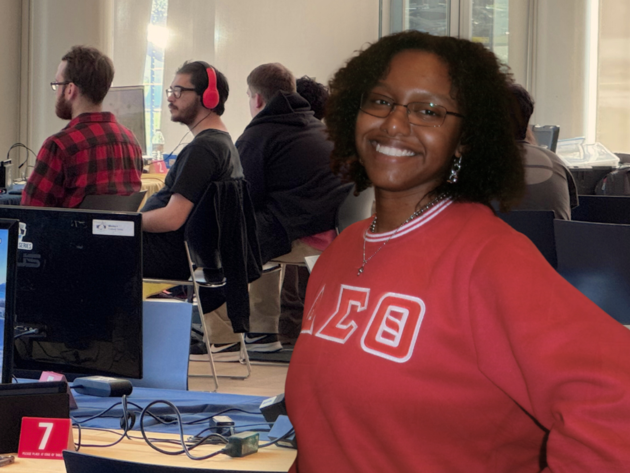 Jennéa Jeter smiling in red AKA sweatshirt